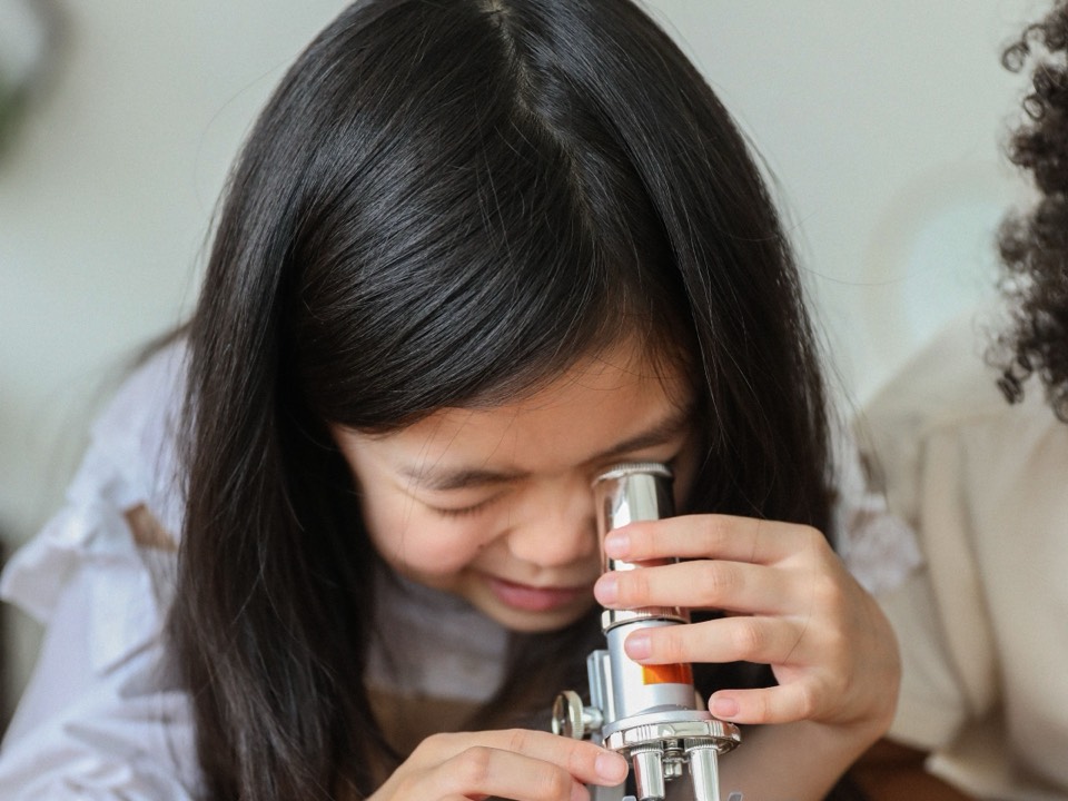 A girl looking into a microscope