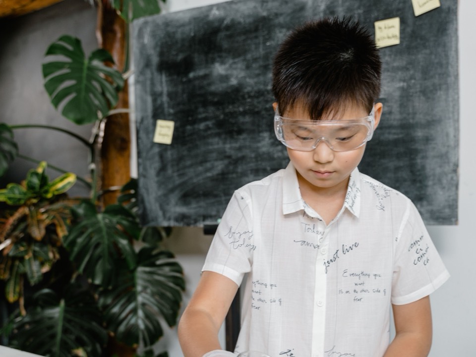 一個戴著護目鏡、在科學實驗桌前的男孩