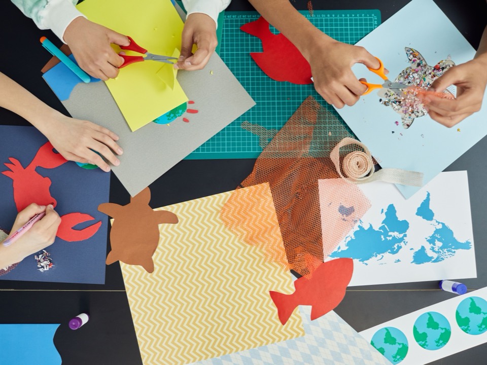 Children cutting out paper shapes for a craft project